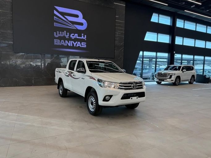 Новый Toyota Hilux VIII Рестайлинг 2, 2.4 л, 2025 в Абу-Даби от Baniyas Cars Abu Dhabi Белый цвет. GCC | AUTO.AE
