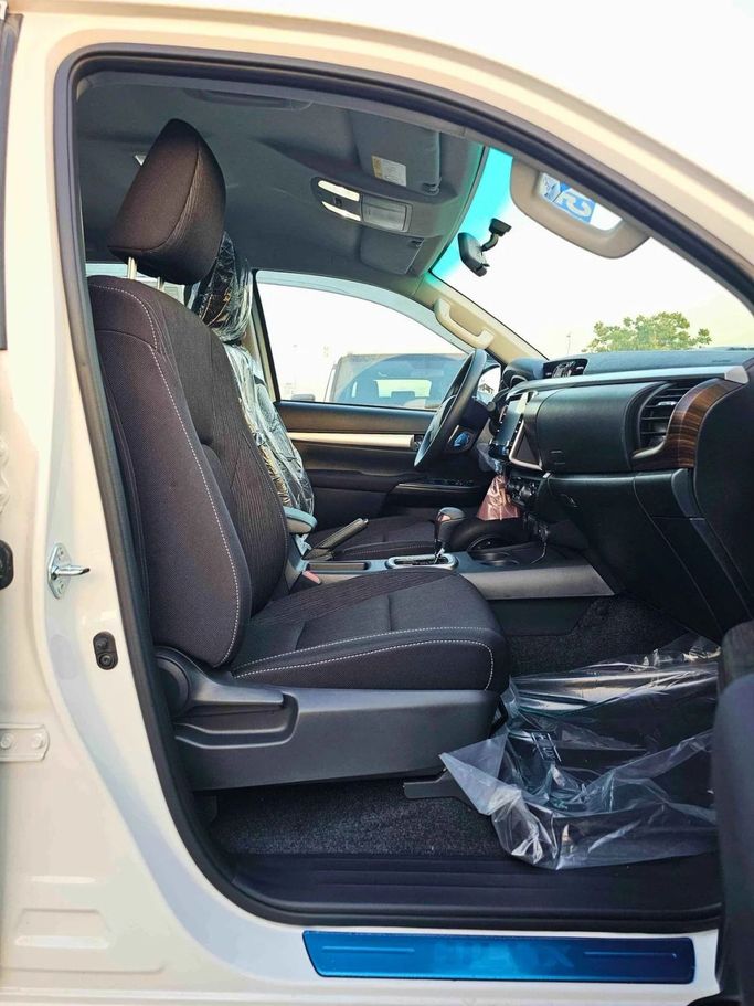New Toyota Hilux VIII Facelift, 2.4 l, 2025 in Dubai by SK Motors, White color. GCC Specs | AUTO.AE