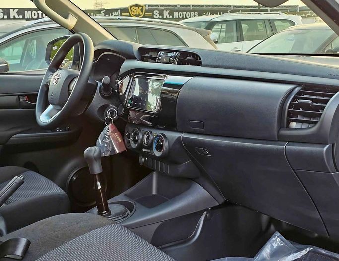 New Toyota Hilux Extra Cab VIII Facelift, 2.4 l, 2025 in Dubai by SK Motors, White color. GCC Specs | AUTO.AE