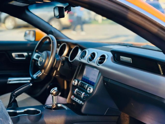 Подержанный Ford Mustang VI Рестайлинг, 2.3 л, 2019 в Шардже от Kandy Cars Оранжевый цвет. Американская | AUTO.AE