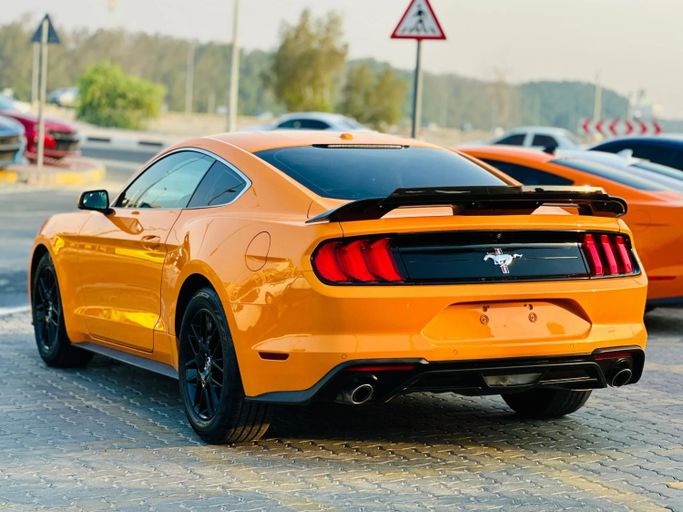 Подержанный Ford Mustang VI Рестайлинг, 2.3 л, 2019 в Шардже от Kandy Cars Оранжевый цвет. Американская | AUTO.AE