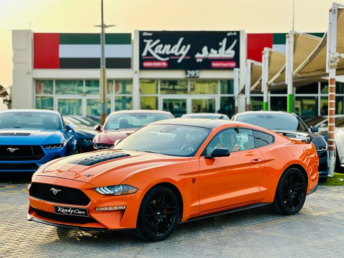 Подержанный Ford Mustang VI Рестайлинг, 2.3 л, 2021 в Шардже от Kandy Cars Оранжевый цвет. Американская | AUTO.AE