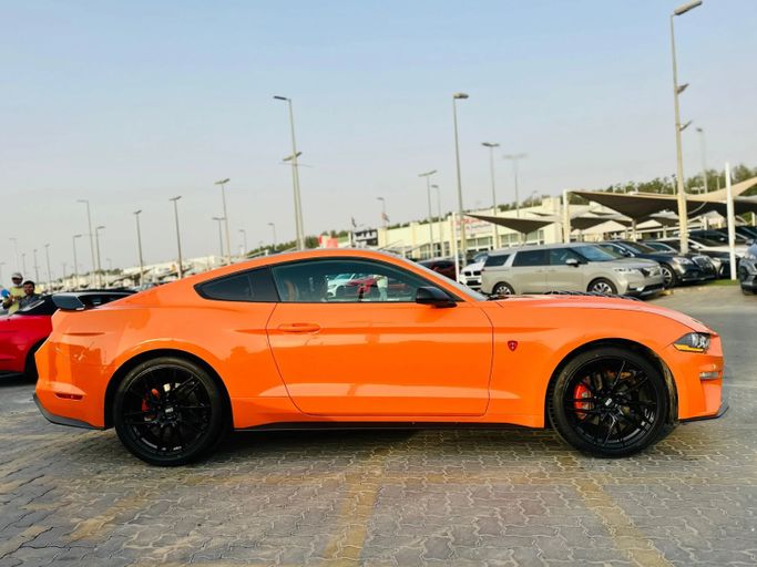 Подержанный Ford Mustang VI Рестайлинг, 2.3 л, 2021 в Шардже от Kandy Cars Оранжевый цвет. Американская | AUTO.AE