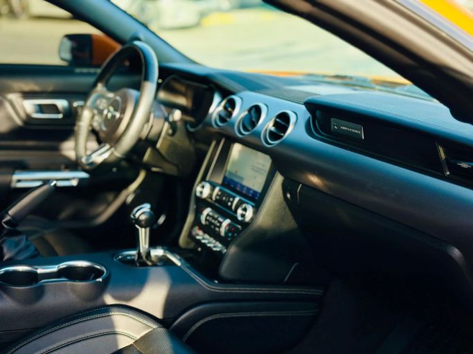 Подержанный Ford Mustang VI Рестайлинг, 2.3 л, 2019 в Шардже от Kandy Cars Оранжевый цвет. Американская | AUTO.AE