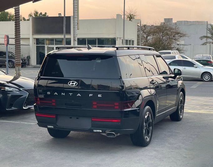 Подержанный Hyundai Santa Fe V (MX5), 2.0 л, 2024 в Шардже от Al Nukhba Al Malakyah Used Cars Черный цвет. Американская | AUTO.AE