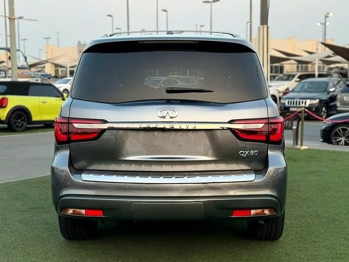 Подержанный Infiniti QX80 I Рестайлинг 2, 5.6 л, 2021 в Шардже от Al Fakhamah Used Cars Серый цвет. Американская | AUTO.AE