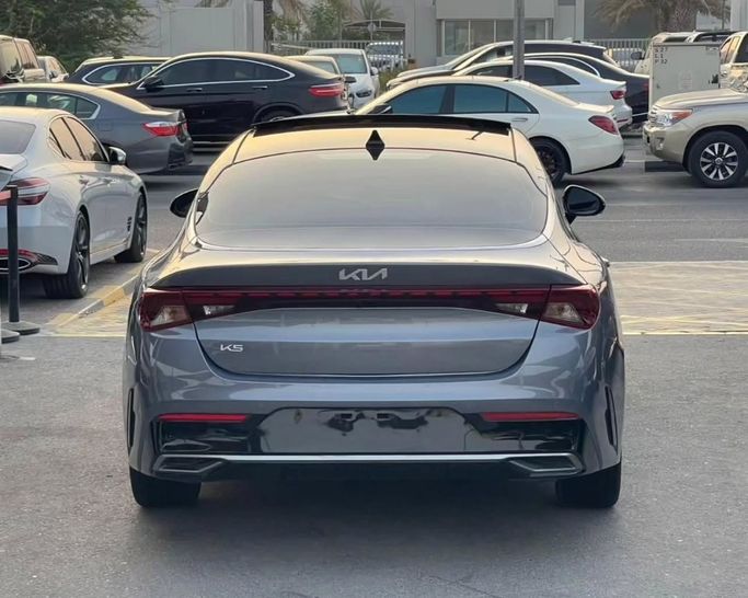 Подержанный Kia K5 III, 1.6 л, 2023 в Шардже от Al Nukhba Al Malakyah Used Cars Серый цвет. Американская | AUTO.AE