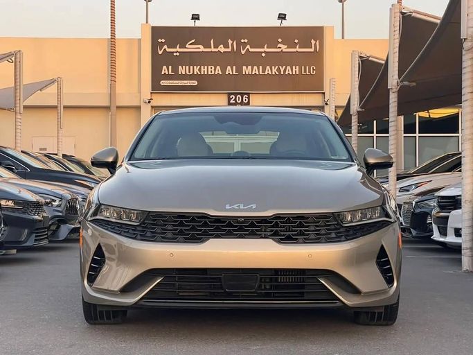 Подержанный Kia K5 III, 1.6 л, 2022 в Шардже от Al Nukhba Al Malakyah Used Cars Золотистый цвет. Американская | AUTO.AE