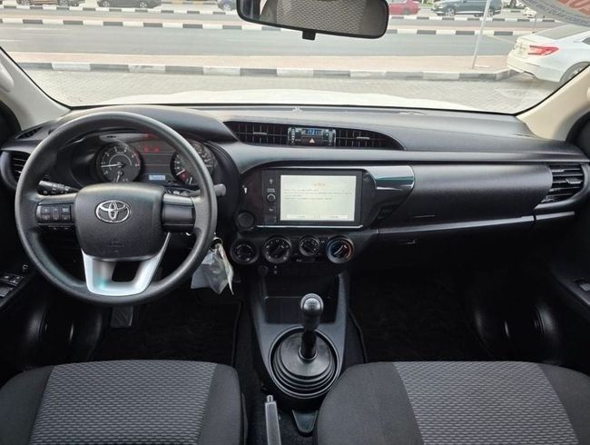 Подержанный Toyota Hilux VIII Рестайлинг, 2.4 л, 2023 в Шардже от Rebou Najd Used Cars Белый цвет. GCC | AUTO.AE
