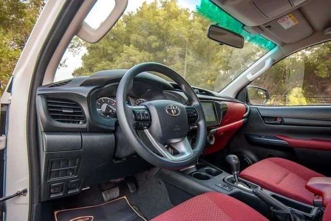 Подержанный Toyota Hilux VIII Рестайлинг 2, 2.8 л, 2024 в Шардже от First Choice Cars Белый цвет. GCC | AUTO.AE