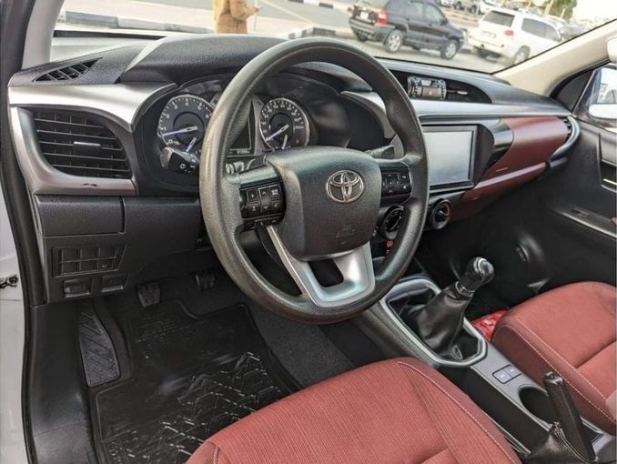 Подержанный Toyota Hilux VIII Рестайлинг, 2.7 л, 2023 в Шардже от Rebou Najd Used Cars Белый цвет. GCC | AUTO.AE