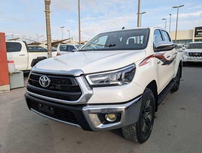 Подержанный Toyota Hilux VIII Рестайлинг, 2.7 л, 2023 в Шардже от Rebou Najd Used Cars Белый цвет. GCC | AUTO.AE